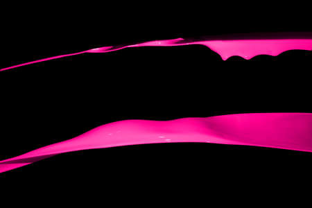 Pink paint splash isolated on black background.の写真素材
