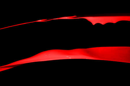 Red paint splash isolated on black background.の写真素材