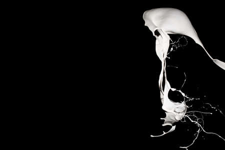 White paint splash isolated on black background.の写真素材