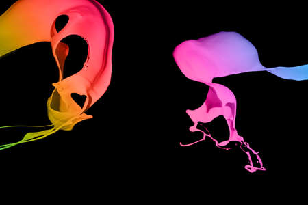 Colorful paint splashing isolated on blackの写真素材