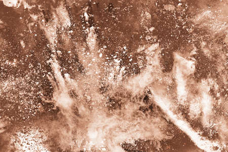 Brown color powder explosion on white background. Colored cloud. Colorful dust explode. Paint Holi.