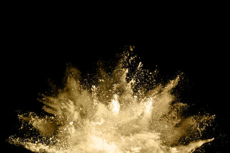 Golden powder explosion on black background. Freeze motion.の写真素材