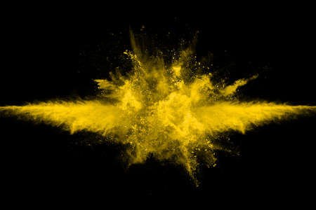 Freeze motion of yellow dust explosion isolated on black background.