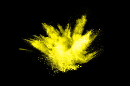 Freeze motion of yellow dust explosion isolated on black background.の写真素材