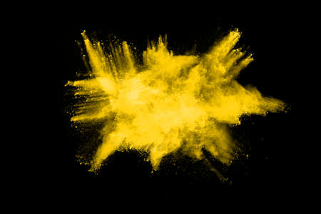 Freeze motion of yellow dust explosion isolated on black background.の写真素材