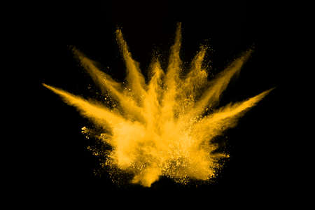 Freeze motion of yellow dust explosion isolated on black background.の写真素材