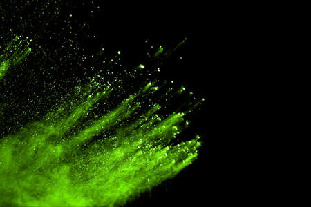 The movement of abstract dust explosion frozen green on black background. Stop the movement of...