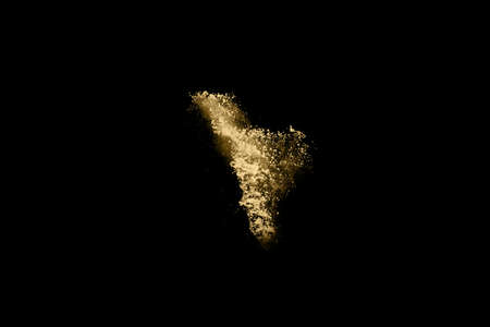Golden powder explosion on black background. Freeze motion.の写真素材