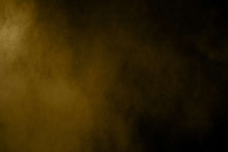 Golden powder explosion on black background. Freeze motion.