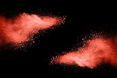 Abstract living coral powder splatted background,Freeze motion of color powder exploding/throwing color powder,color glitter texture on black background.の写真素材
