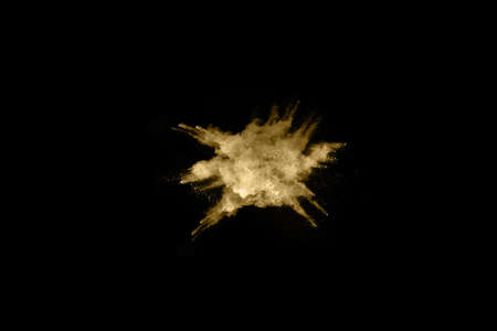 Golden powder explosion on black background. Freeze motion.