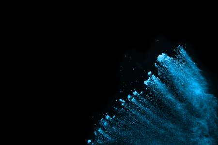 Blue powder explosion on black background. Colored cloud. Colorful dust explode. Paint Holi.の写真素材
