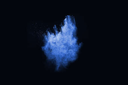 Blue powder explosion on black background. Colored cloud. Colorful dust explode. Paint Holi.の写真素材