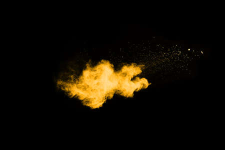 Freeze motion of yellow dust explosion isolated on black background.の写真素材