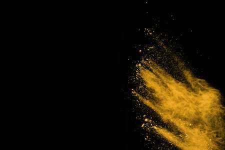 Freeze motion of yellow dust explosion isolated on black background.の写真素材