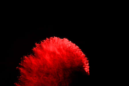 abstract red powder explosion on black background.abstract red powder splatted on black background....