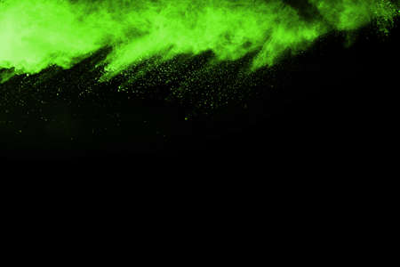 The movement of abstract dust explosion frozen green on black background. Stop the movement of powdered green on black background. Explosive powder green on black background.の写真素材