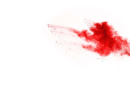 Freeze motion of red powder exploding, isolated on white background. Abstract design of red dust...