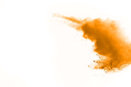 Powder explosion. Closeup of a yellow dust particle explosion isolated on white. Abstract backgroundの写真素材