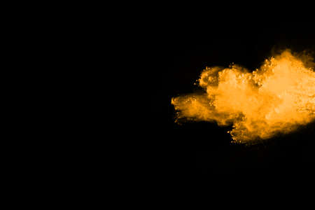 Freeze motion of yellow dust explosion isolated on black background.の写真素材