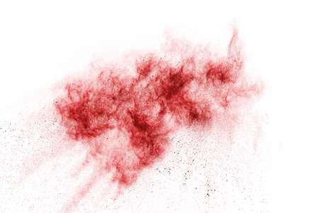 Freeze motion of red powder exploding, isolated on white background. Abstract design of red dust...