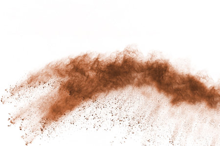 Brown color powder explosion on white background. Colored cloud. Colorful dust explode. Paint Holi.の写真素材