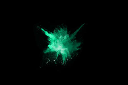 The movement of abstract dust explosion frozen green on black background. Stop the movement of powdered green on black background. Explosive powder green on black background.の写真素材
