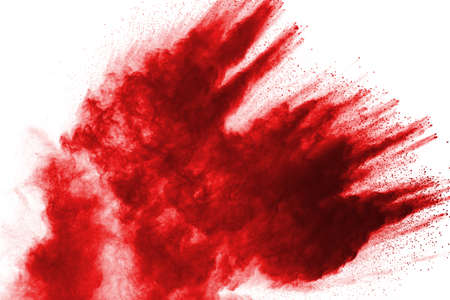 Freeze motion of red powder exploding, isolated on white background. Abstract design of red dust...