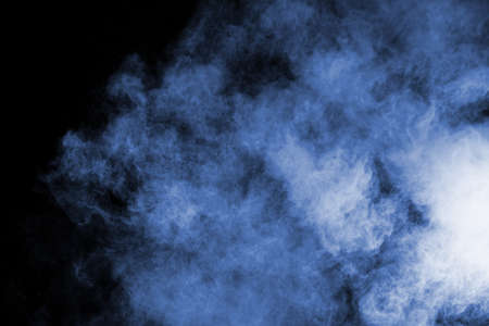 Blue powder explosion on black background. Colored cloud. Colorful dust explode. Paint Holi.