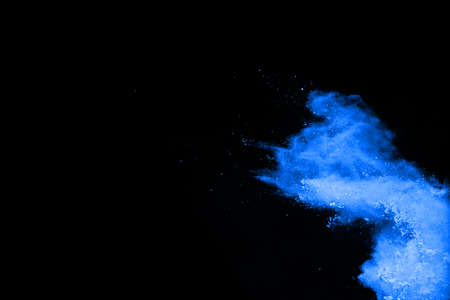 Blue powder explosion on black background. Colored cloud. Colorful dust explode. Paint Holi.の写真素材