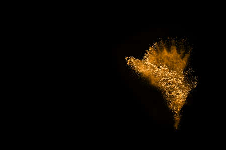 Freeze motion of yellow dust explosion isolated on black background.の写真素材