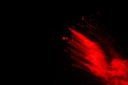 abstract red powder explosion on black background.abstract red powder splatted on black background. Freeze motion of red powder exploding.の写真素材