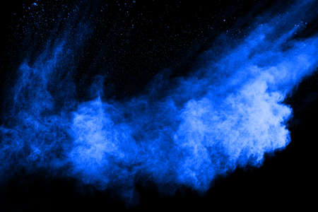 Blue powder explosion on black background. Colored cloud. Colorful dust explode. Paint Holi.の写真素材