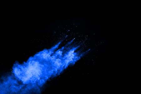 Blue powder explosion on black background. Colored cloud. Colorful dust explode. Paint Holi.の写真素材