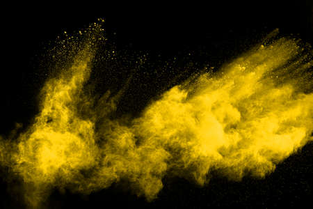 Freeze motion of yellow dust explosion isolated on black background.の写真素材
