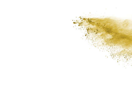 Powder explosion. Closeup of a yellow dust particle explosion isolated on white. Abstract backgroundの写真素材