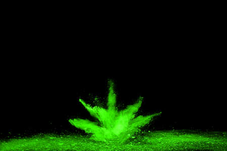 The movement of abstract dust explosion frozen green on black background. Stop the movement of powdered green on black background. Explosive powder green on black background.の写真素材