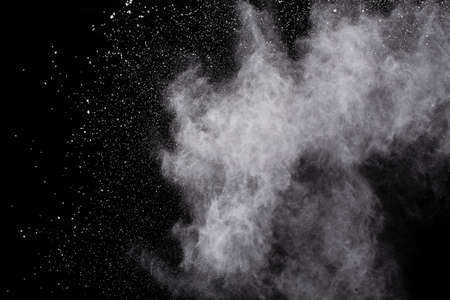 White powder explosion on black background. Colored cloud. Colorful dust explode. Paint Holi.の写真素材