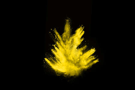 Freeze motion of yellow dust explosion isolated on black background.の写真素材