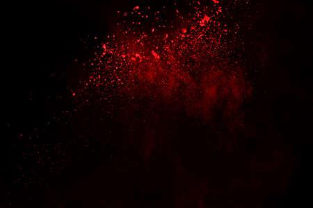abstract red powder explosion on black background.abstract red powder splatted on black background. Freeze motion of red powder exploding.の写真素材