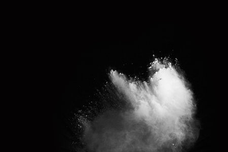 White powder explosion on black background. Colored cloud. Colorful dust explode. Paint Holi.の写真素材