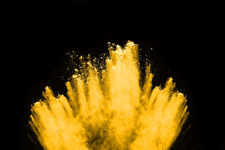Freeze motion of yellow dust explosion isolated on black background.の写真素材