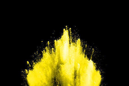 Freeze motion of yellow dust explosion isolated on black background.の写真素材