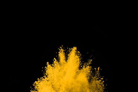 Freeze motion of yellow dust explosion isolated on black background.の写真素材