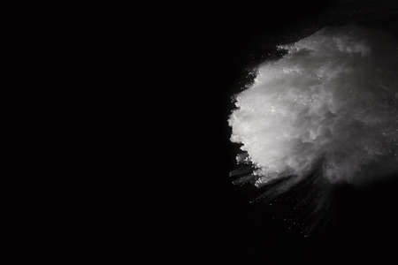 White powder explosion on black background. Colored cloud. Colorful dust explode. Paint Holi.