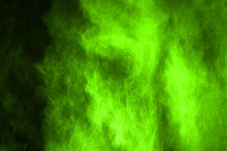 The movement of abstract dust explosion frozen green on black background. Stop the movement of...