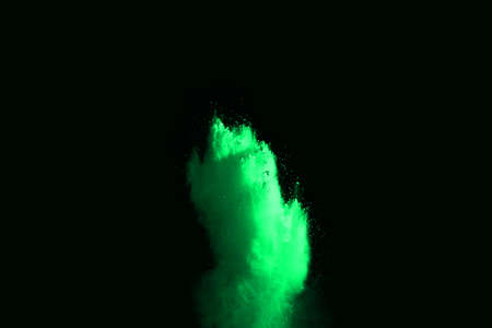 The movement of abstract dust explosion frozen green on black background. Stop the movement of...