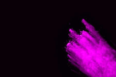 Pink powder explosion on black background. Colored cloud. Colorful dust explode. Paint Holi.の写真素材