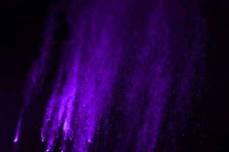 The movement of abstract dust explosion frozen purple on black background. Stop the movement of...