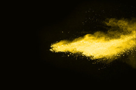 Freeze motion of yellow dust explosion isolated on black background.の写真素材